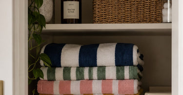 Striped beach towel in a storage cupboard.